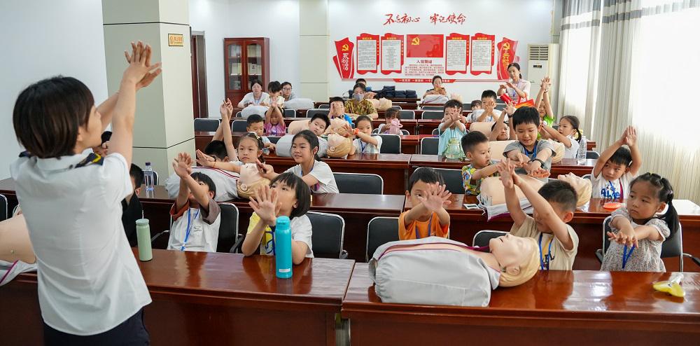 5.孩子們跟著講解員老師學(xué)習(xí)心肺復(fù)蘇急救知識.jpg